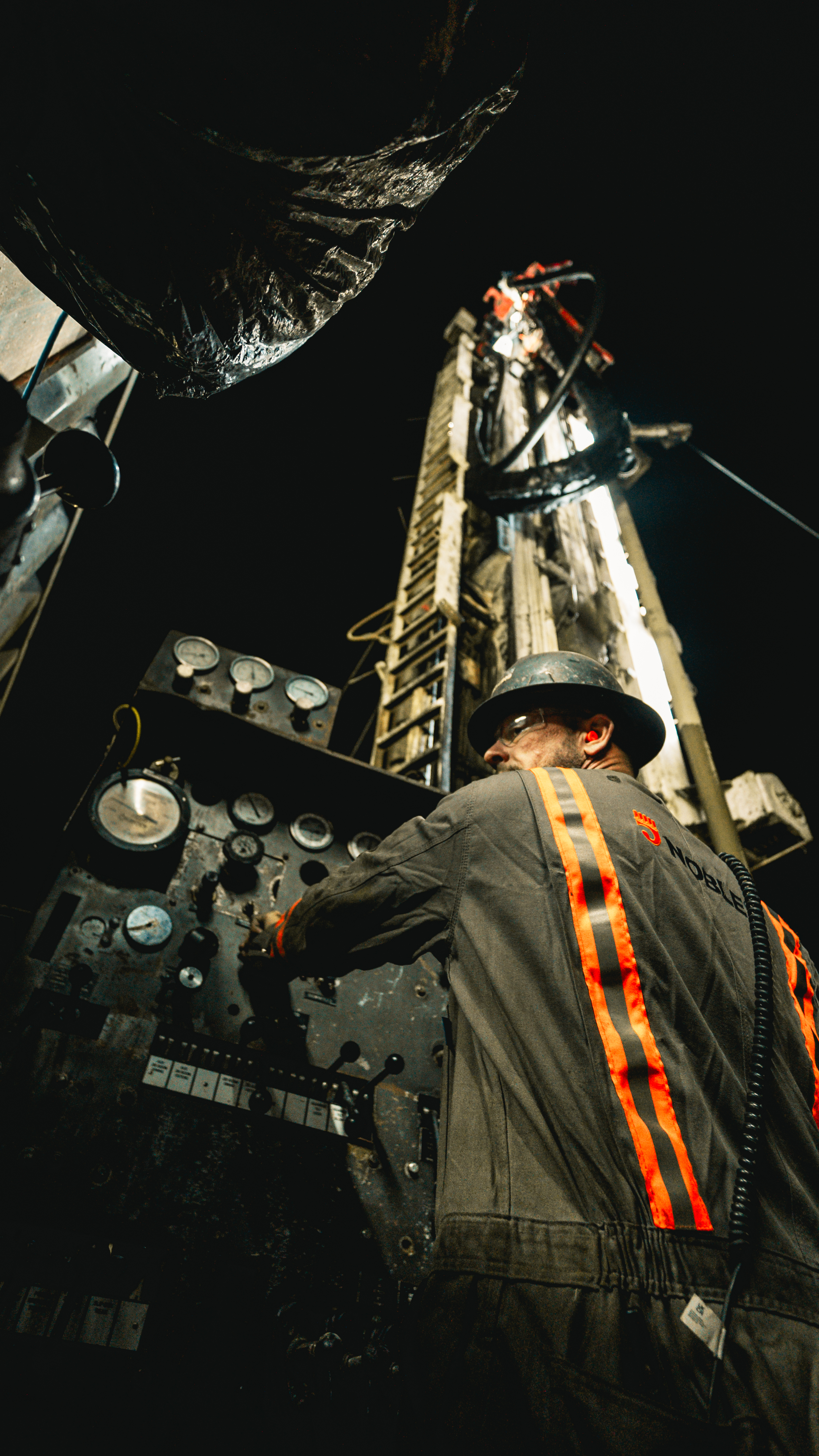 Worker at rig controls, night